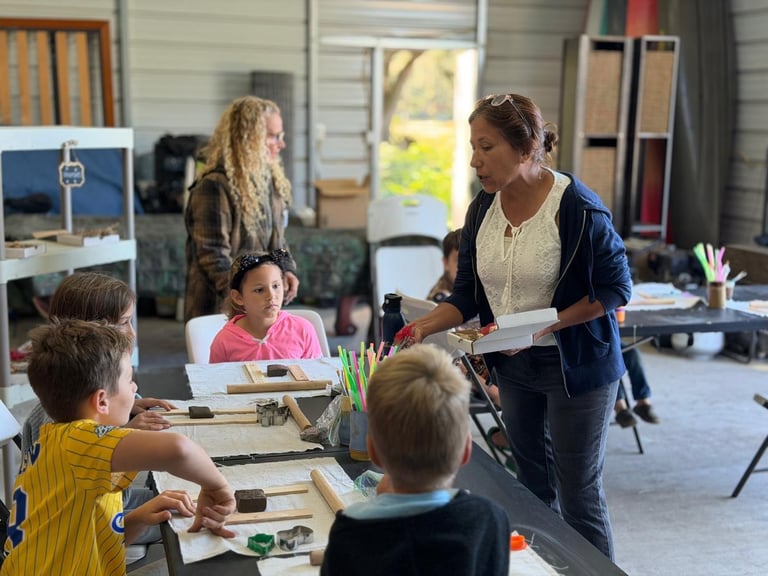 Woman serving food to a young boy at a community food bank or volunteer event with other people in the background